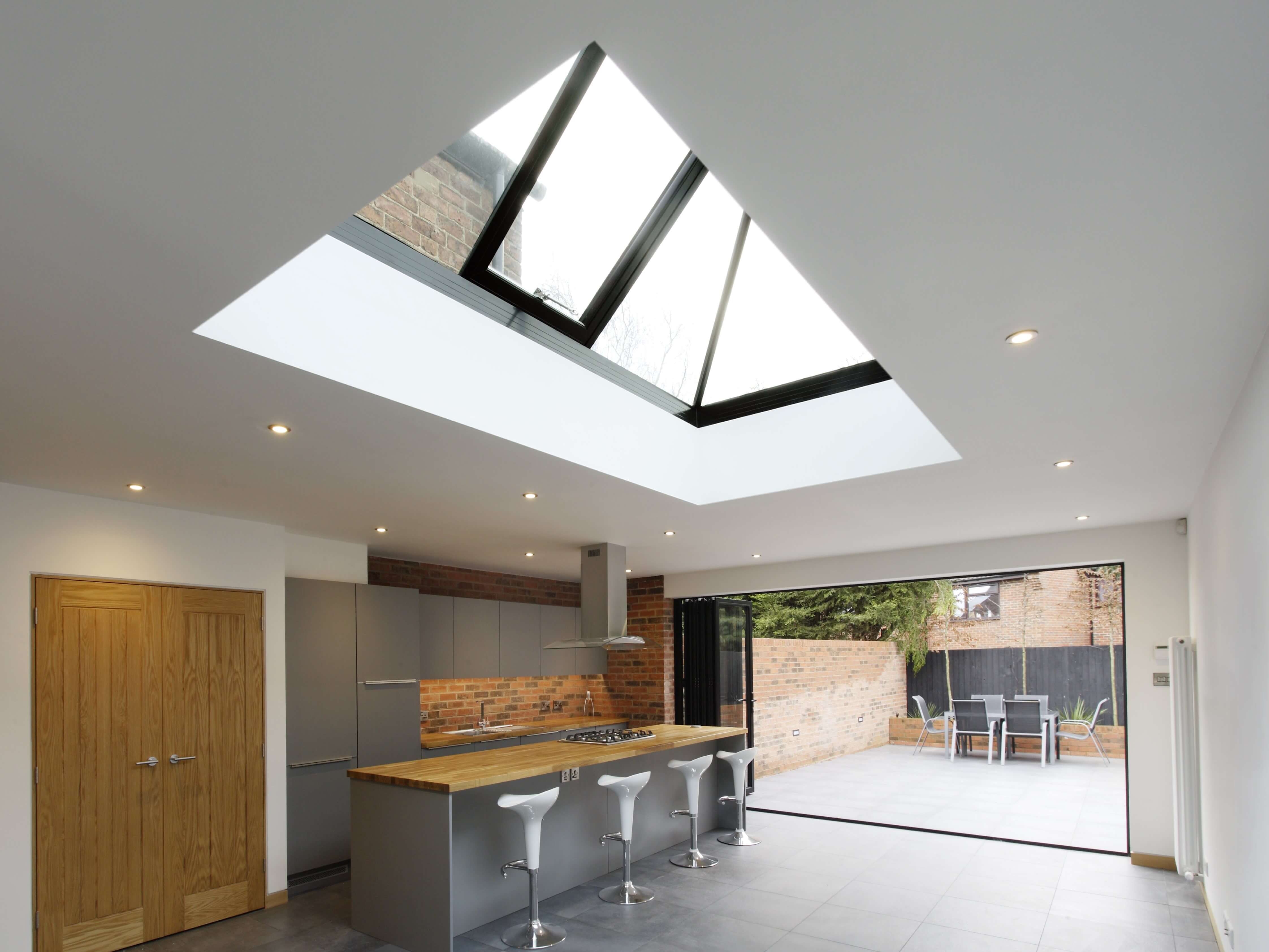 Bi-fold doors opening onto a contemporary garden, with a vented lantern above