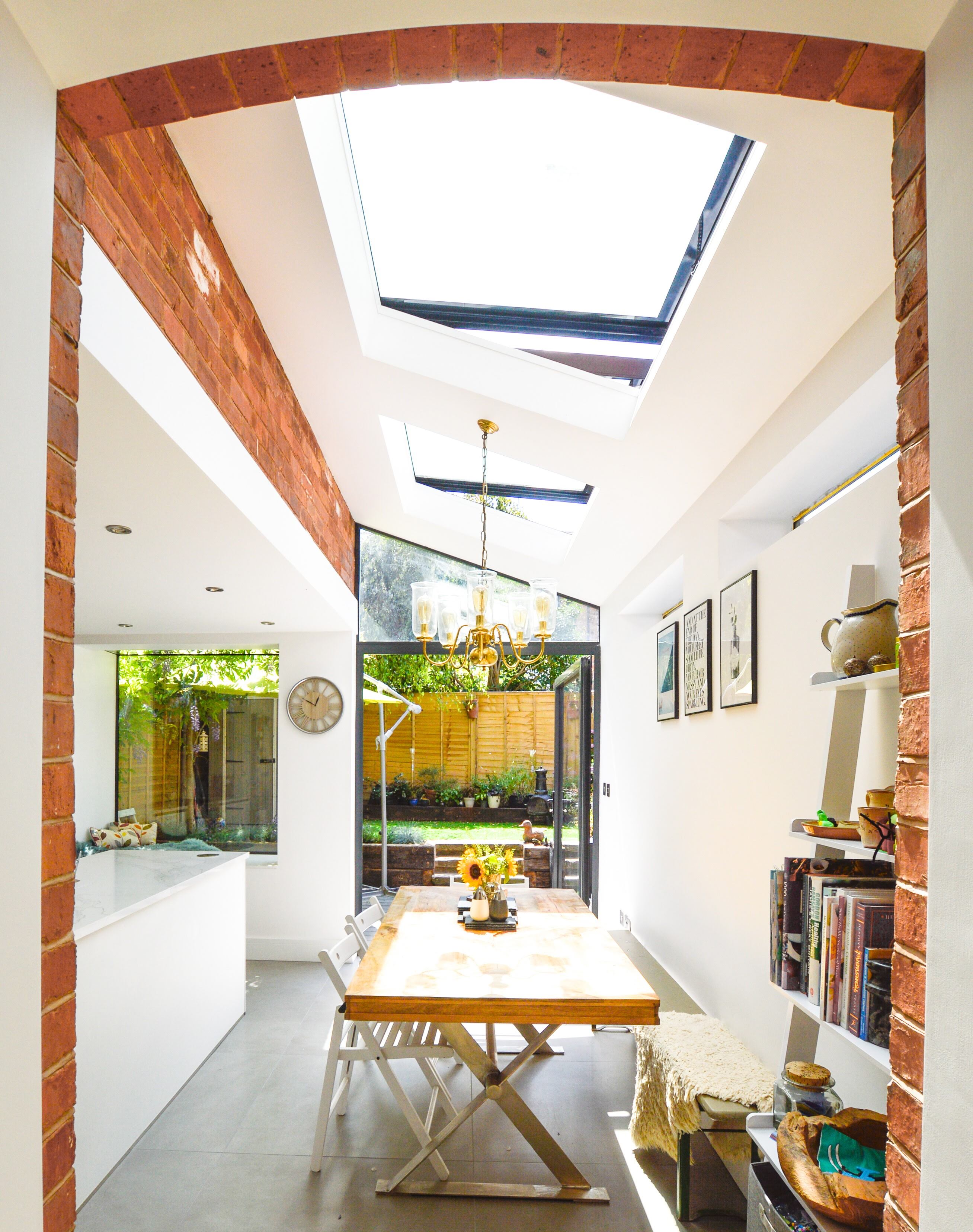 Small kitchen and dining area with exposed brick walls and two opening pitched rooflights.