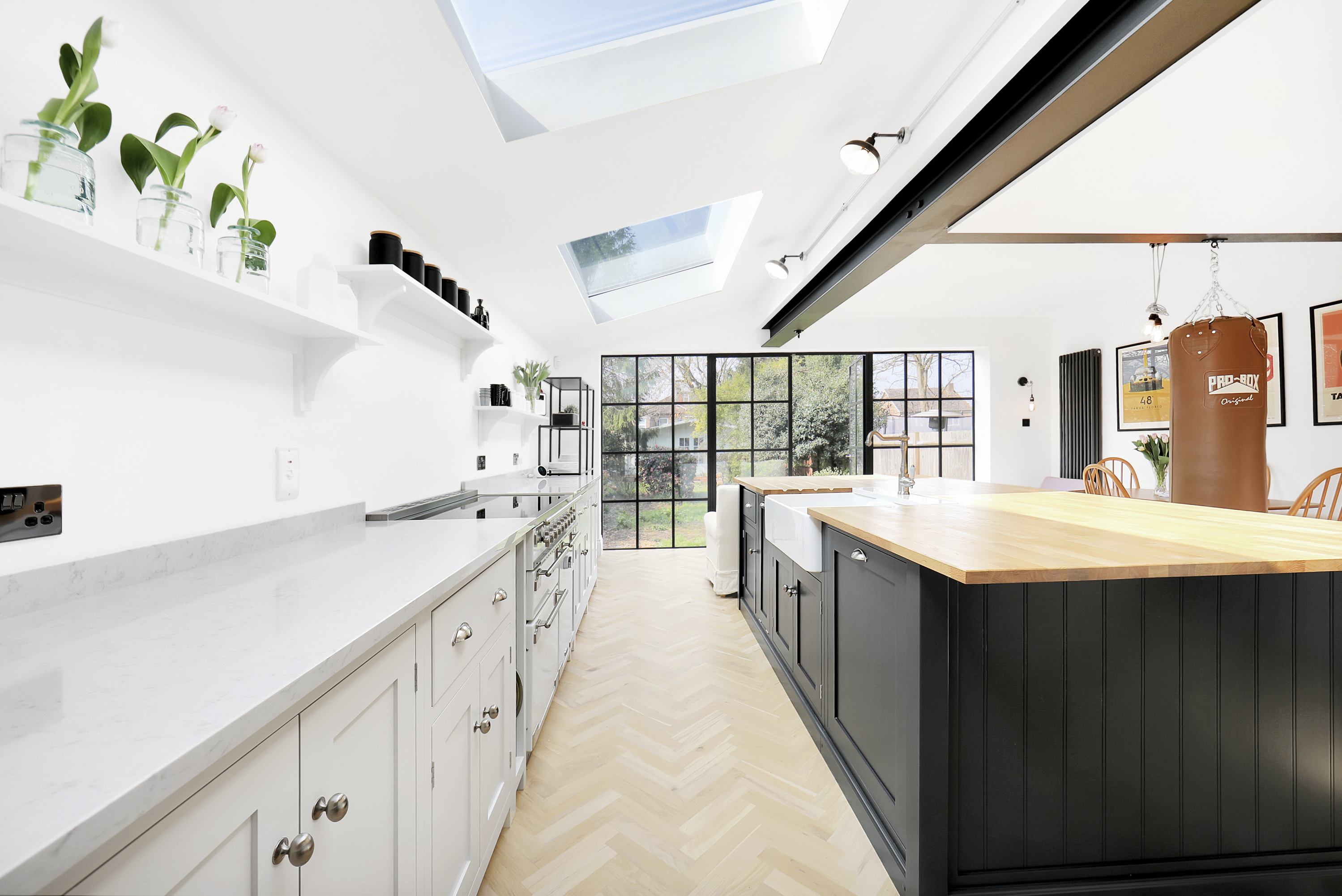 Open kitchen area with large modern counters and two pitched skylights.