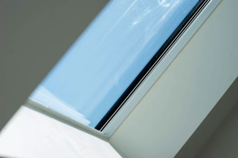 Looking up to blue sky through pitched skylight