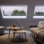 Cosy living area, at evening time, with large pitched rooflight and candles